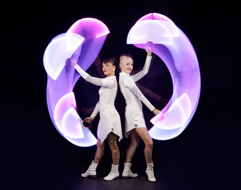Duo de danseuses LED en performance lumineuse lors d’un événement.